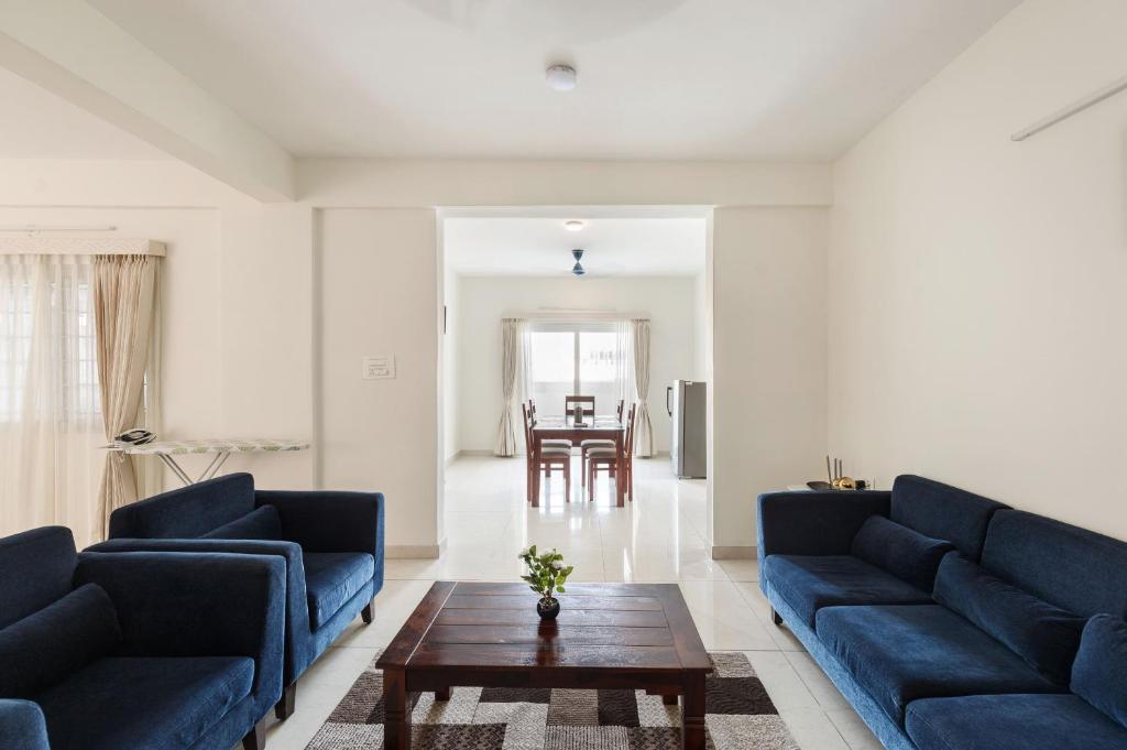 班加羅爾的住宿－Mistyblue Stays，客厅配有蓝色的沙发和桌子