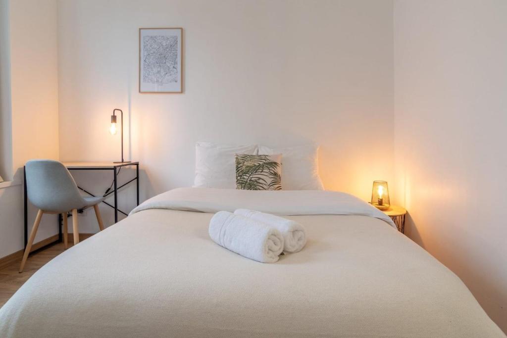 1 dormitorio con 1 cama y 2 toallas blancas en Lille Centre - Nice & functional studio en Lille