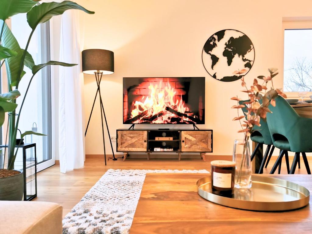 a living room with a fire in the fireplace at Fynbos Deluxe, Penthouse oder Balkon, Parkplatz in Straubing