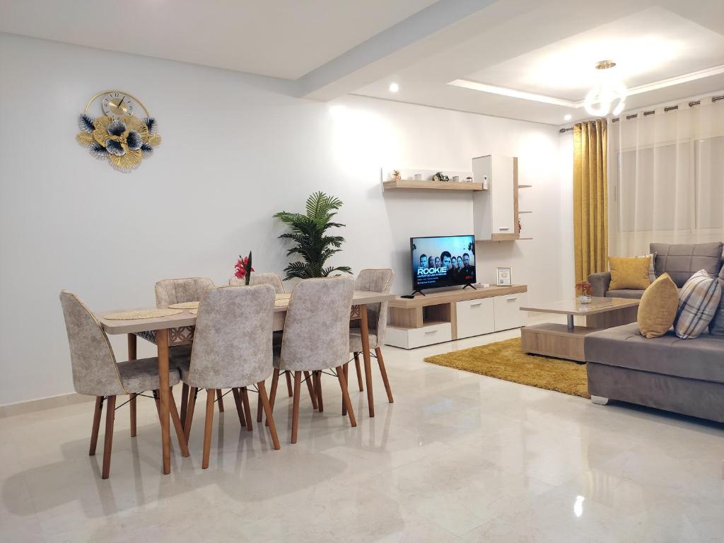 a living room with a table and chairs and a couch at DLX03 - Appartement Deluxe 2 chambres - Centre Ville Oujda in Oujda