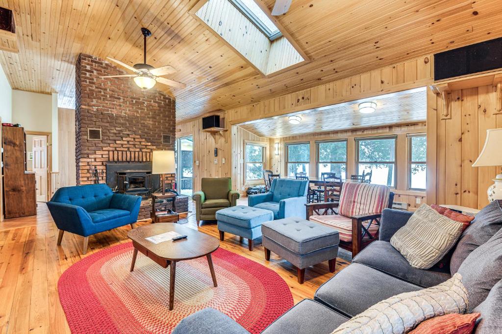 uma sala de estar com mobiliário azul e uma lareira em Waterfront North Hero Home with Screened Porch em North Hero