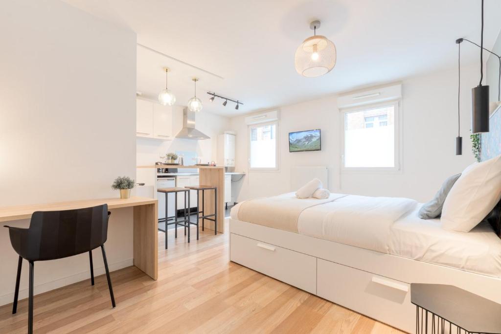 une chambre blanche avec un lit et une cuisine dans l'établissement Wazemmes - Functional studio with parking space!, à Lille