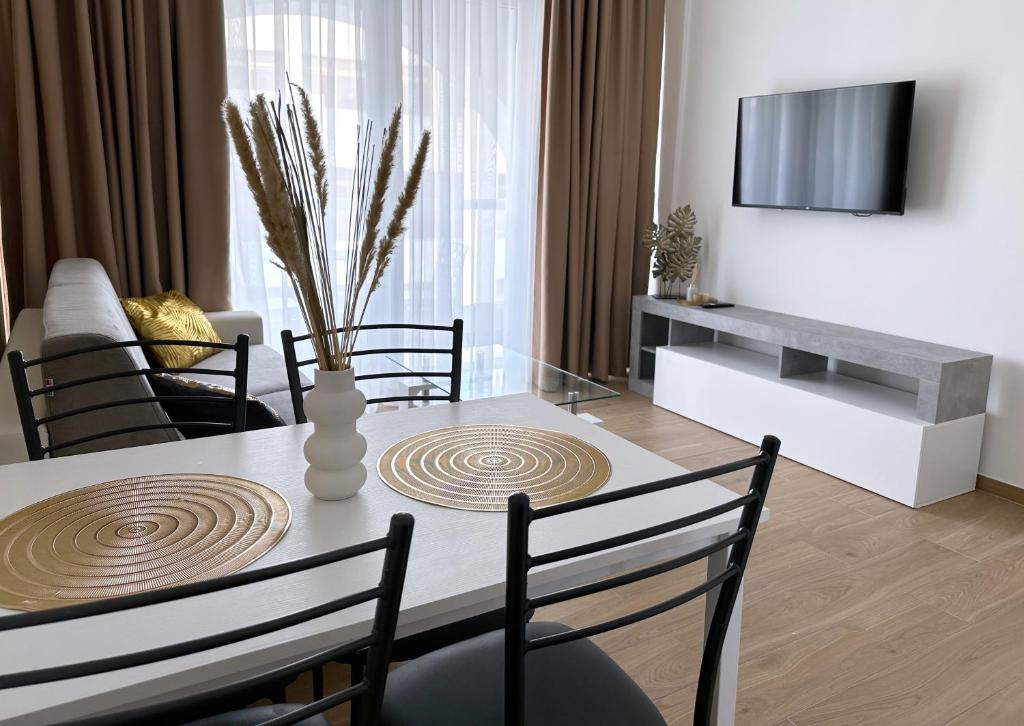 a living room with a dining room table with chairs at Miami Apartments in St. Julianʼs
