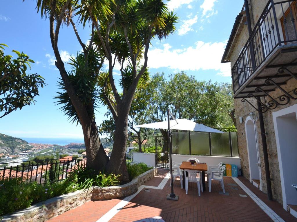 d'une terrasse avec une table et un arbre. dans l'établissement Belvilla by OYO Ventimiglia, à Vintimille
