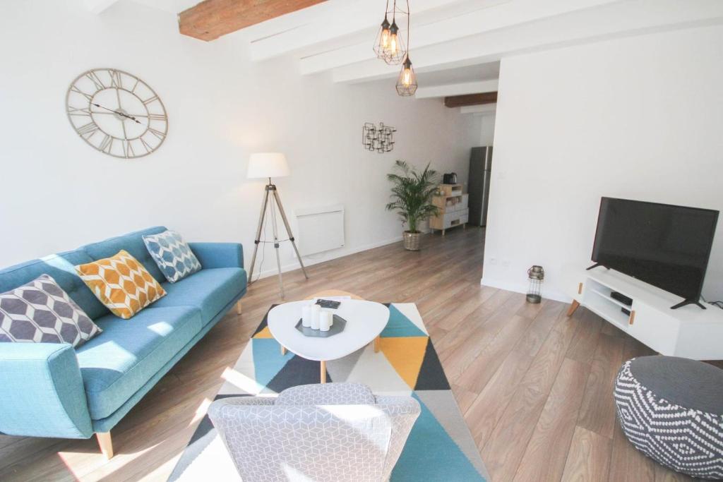 a living room with a blue couch and a tv at Vieux Lille: bright, functional apartment in Lille