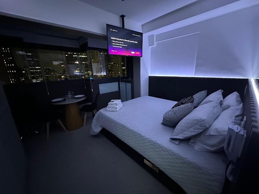 um quarto com uma cama com um monitor por cima em Ap Luxo Jardins Cd 1714 em São Paulo