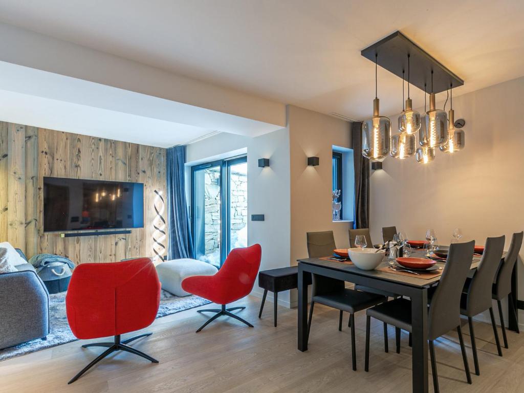 une salle à manger avec une table et des chaises rouges dans l'établissement Appartement de standing avec Wi-Fi, garage, terrasse et accès direct aux pistes à Val-d'Isère - FR-1-694-348, à Val dʼIsère
