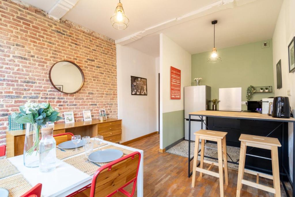 une cuisine et une salle à manger avec un mur en briques dans l'établissement Vieux Lille on rue de la Monnaie!, à Lille