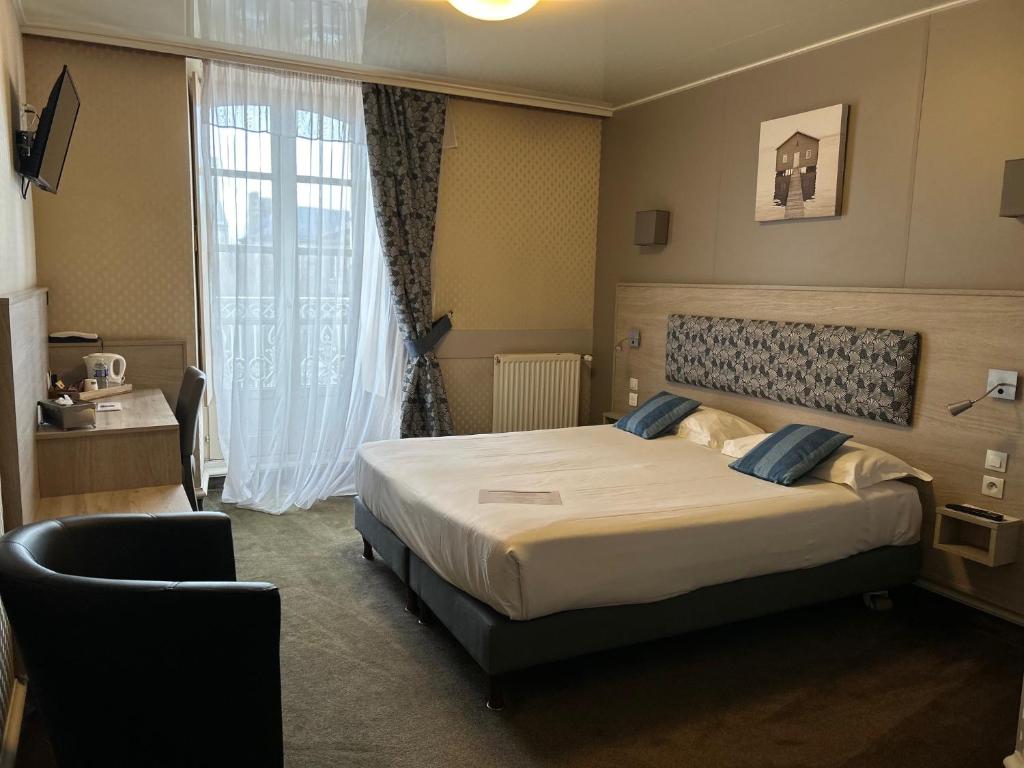 1 dormitorio con cama y ventana grande en Cit'Hotel le Challonge en Dinan