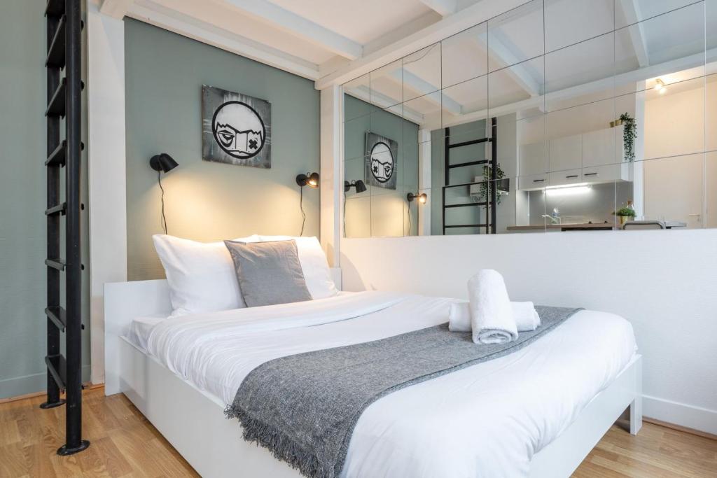 1 dormitorio con 1 cama blanca grande con almohadas blancas en Lille Saint Maurice - Nice and functional studio en Lille