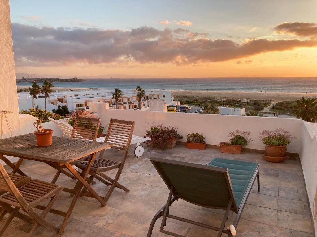 a patio with a table and chairs and the beach at Apartamento Frente Al Mar in Tarifa