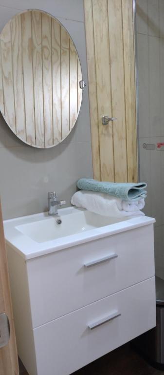 uma casa de banho com um lavatório branco e um espelho. em Cabaña Los Maquis en Castro em Castro
