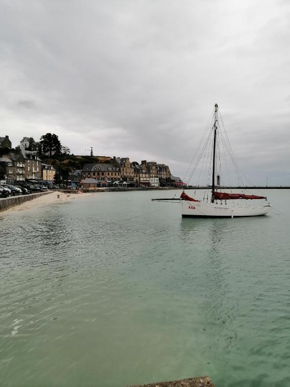 un bateau assis dans l'eau à côté d'une plage dans l'établissement Studio 5 proche du port, à Cancale