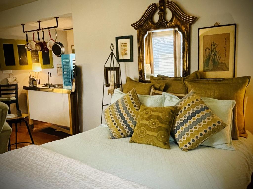 a bedroom with a bed with pillows on it at The Coziest Cottage in Waxahachie in Waxahachie