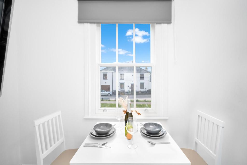un comedor blanco con mesa y ventana en Fabulous Apartment Overlooking Canal - Parking - Perry Barr - WIFI - Netflix - 3PB, en Birmingham