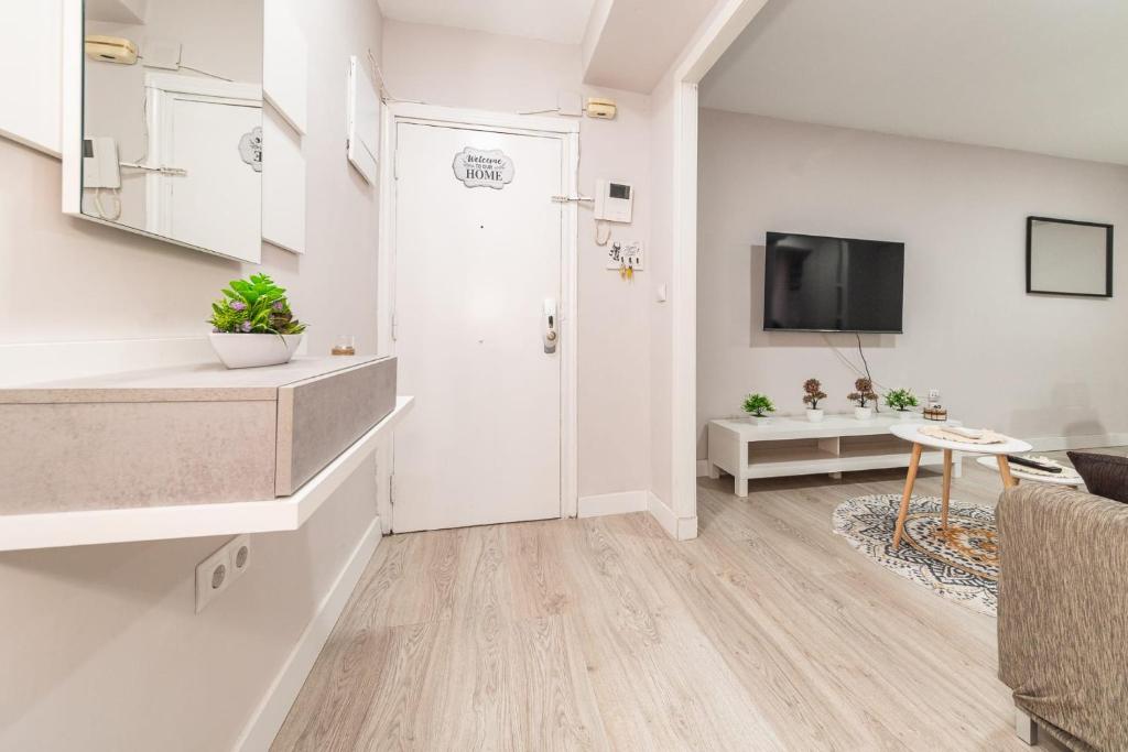 sala de estar con puerta blanca y TV en Elegant 6 pax apartment in Plaza Eliptica - SM17, en Madrid