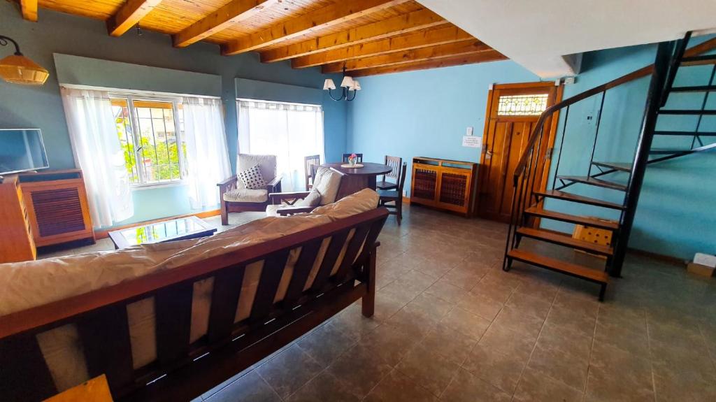 sala de estar con sofá y escalera en Achalay Houses en San Carlos de Bariloche