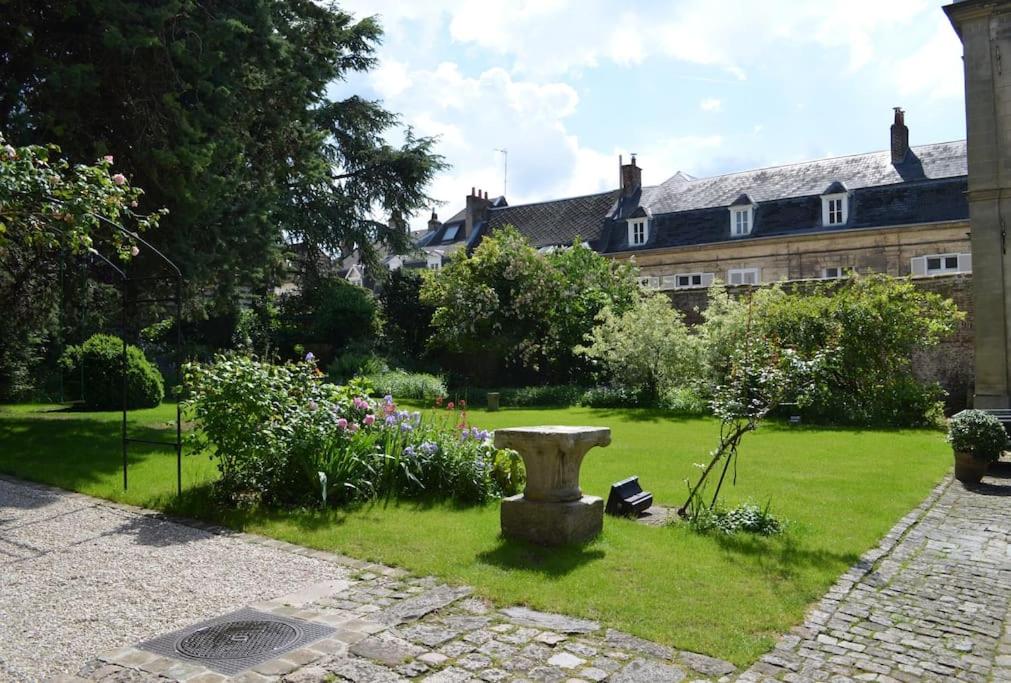 un jardín con un baño de aves en el césped en Jardin de la Préfecture, en Arras