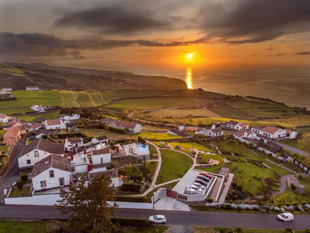 uma vista aérea de uma aldeia com o pôr-do-sol sobre o oceano em Tradicampo Eco Country Houses em Nordeste