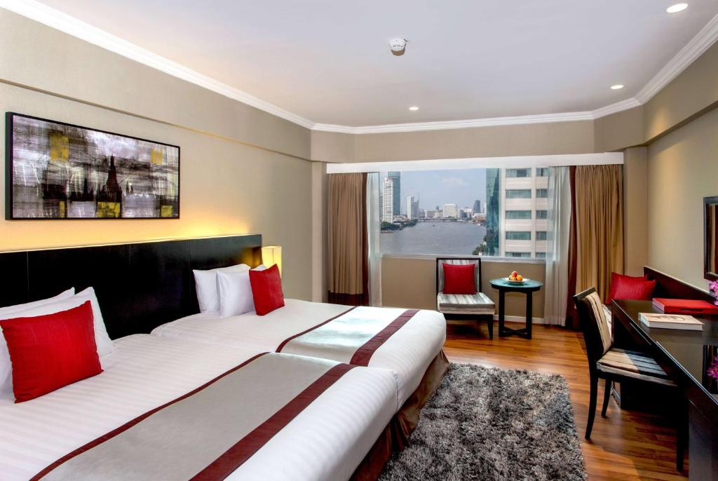 A two-bed room with a river-and-city outlook and an in-room work area.