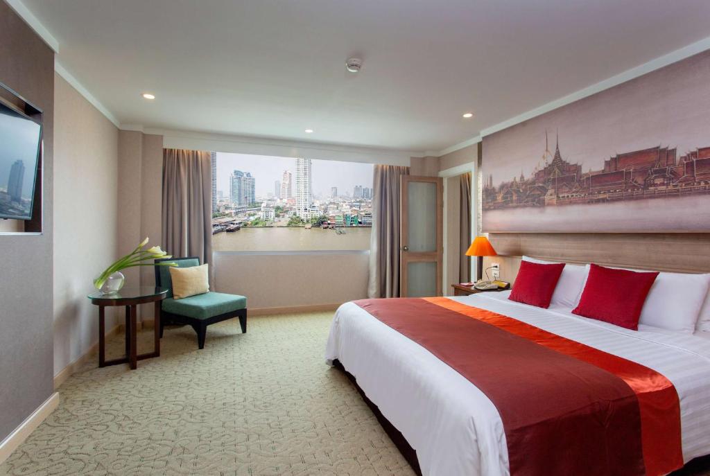 A king room with a broad river-and-city outlook and a small reading chair.