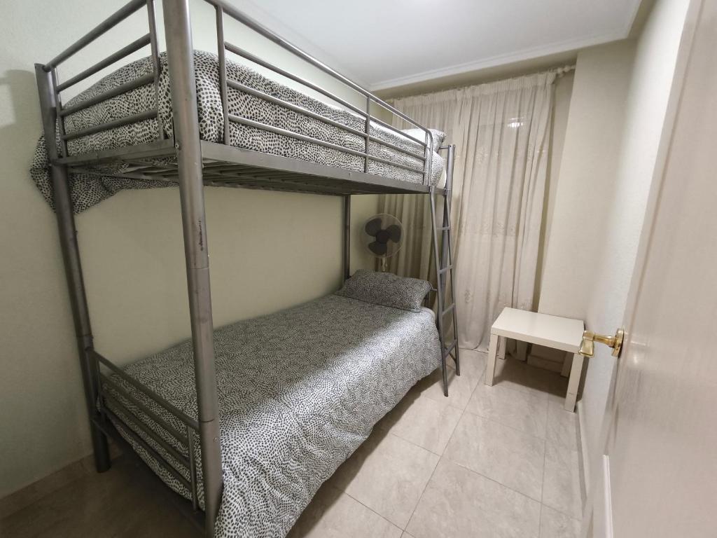 a bedroom with a bunk bed and a table at Beach and sun guest house in Torrevieja