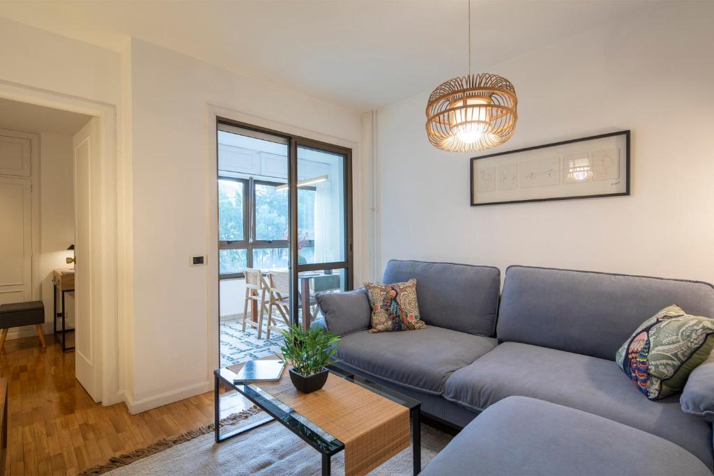 uma sala de estar com um sofá e uma mesa em Coqueto apartamento, céntrico, con garaje y piscina by Prishomes em Vigo