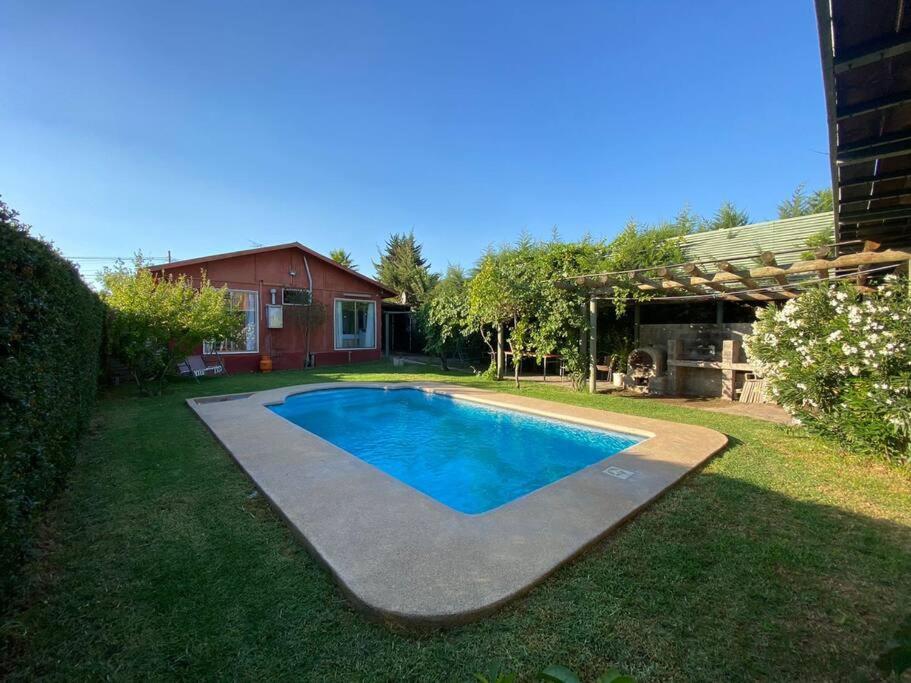 ein Schwimmbad in einem Hof neben einem Haus in der Unterkunft Casa Lago Rapel in Llallauquén