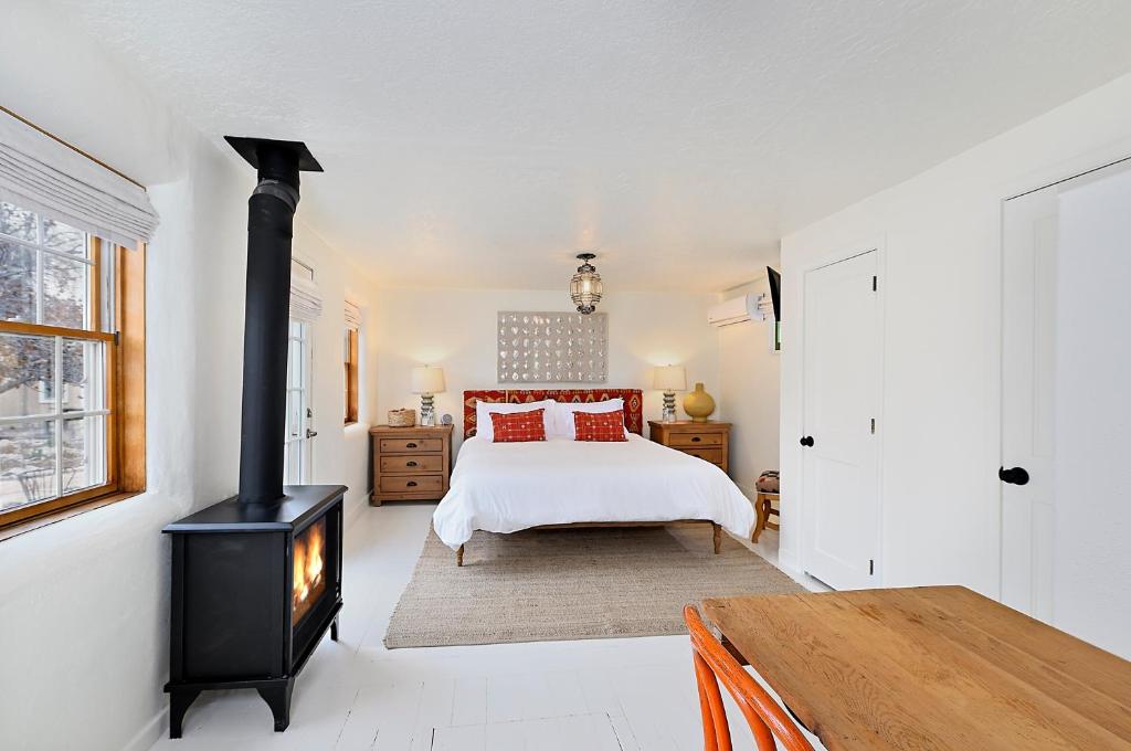 1 dormitorio con 1 cama y estufa de leña en Dos Hermanas Casita 1 Downtown Cozy Studio, en Santa Fe