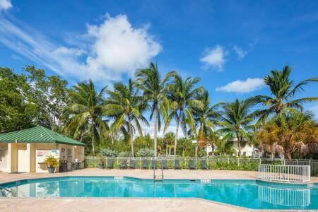 una piscina con palmeras en el fondo en NEW Grenada Suite - Parking Pool & Pets 209, en Key West