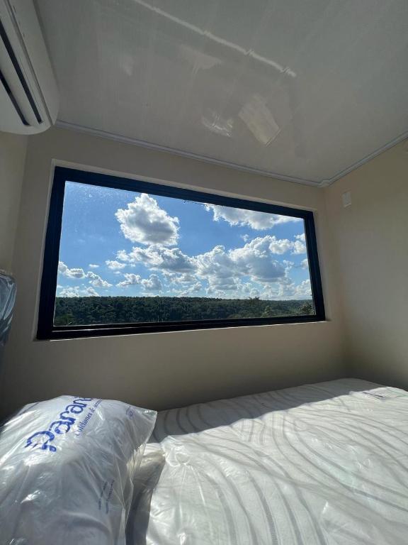 a bed in a room with a large window at Container Home Py in Puerto Presidente Franco