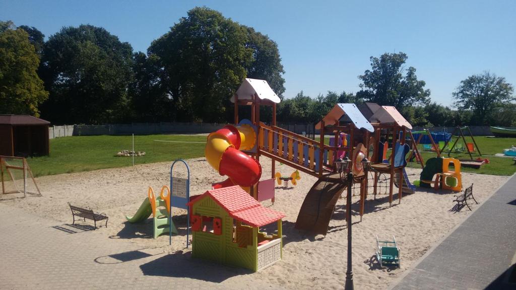 a playground with a slide and play equipment in the sand at Agroturystyka nad Morzem in Ustka