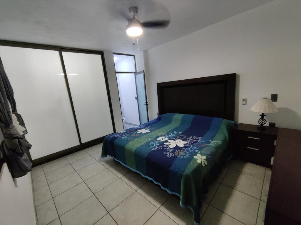 a bedroom with a bed with a blue comforter at Los Equipales in Guadalajara