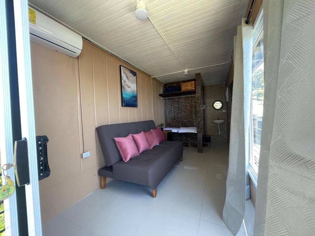 eine Couch mit zwei rosa Kissen in einem Zimmer in der Unterkunft Blue View by Ronny’s Place in Quepos