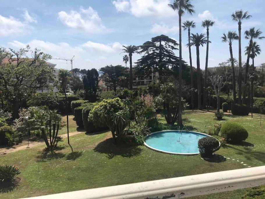 a garden with a small pool in the grass at BEL APPARTEMENT-PROCHE MER-TERRASSE in Cannes