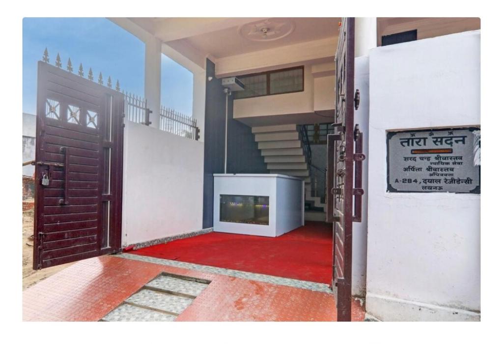 an open door to a room with a red carpet at Apna Guest House in Lucknow