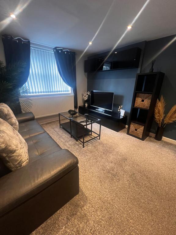 a living room with a couch and a television at Ty Daisy, Gilwern in Gilwern