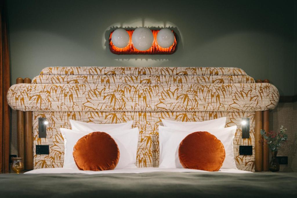 - un lit avec des oreillers blancs et une tête de lit dans l'établissement 1,75 Paris La Sève, à Paris