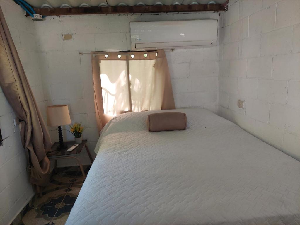 Habitación pequeña con cama y ventana en Coquimbo Beach, en La Libertad
