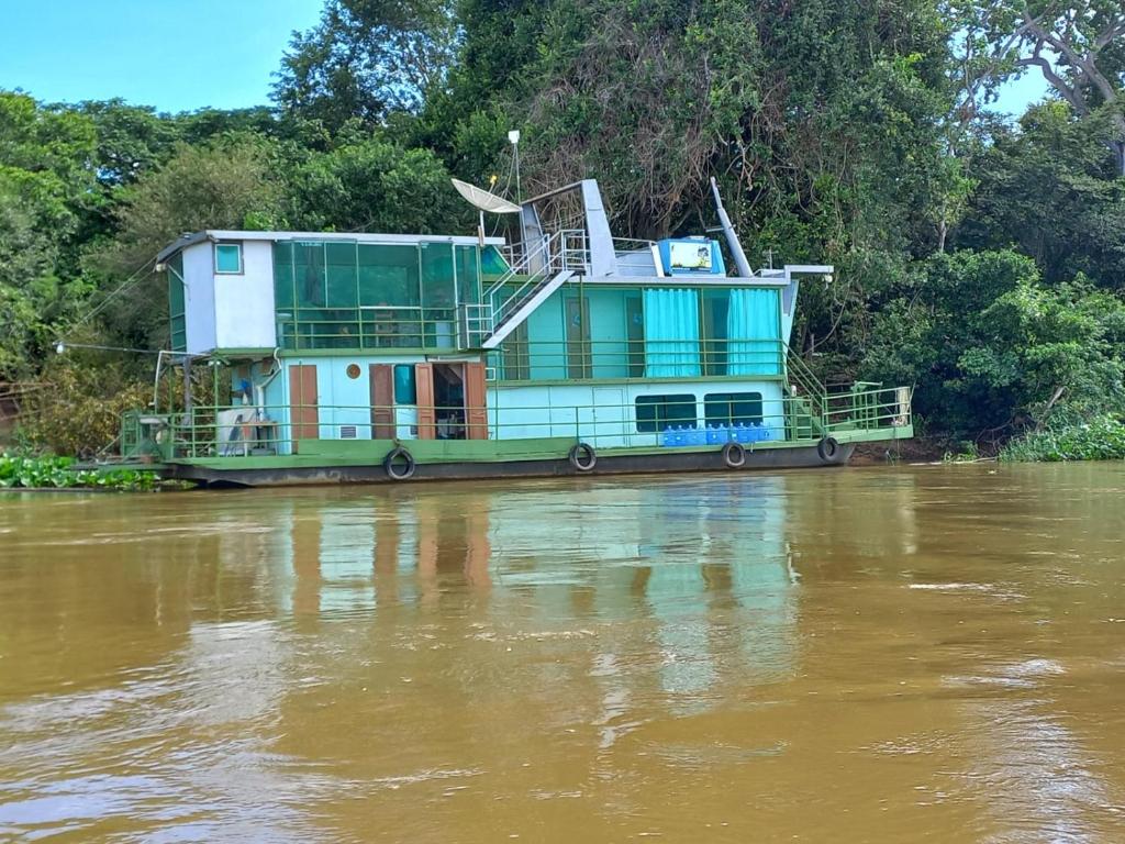un bateau est assis sur une rivière dans l'établissement Barco Casa Pantanal Toca da Onça, à Poconé