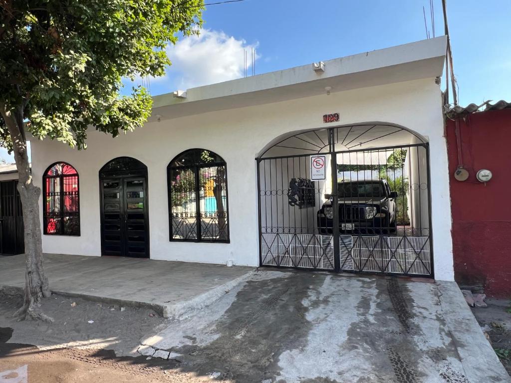 a building with a garage with a car in it at La Casa Blanca in Tecomán