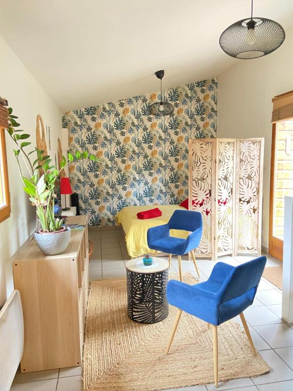 - une chambre avec un lit et deux chaises bleues dans l'établissement La Tiny House au bord de l'eau, à Saint-Hilaire-Saint-Mesmin