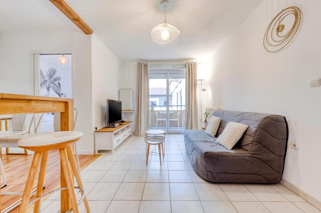 un salon avec un canapé et une télévision dans l'établissement Charmant T2 Top Emplacement avec Parking, à Montpellier