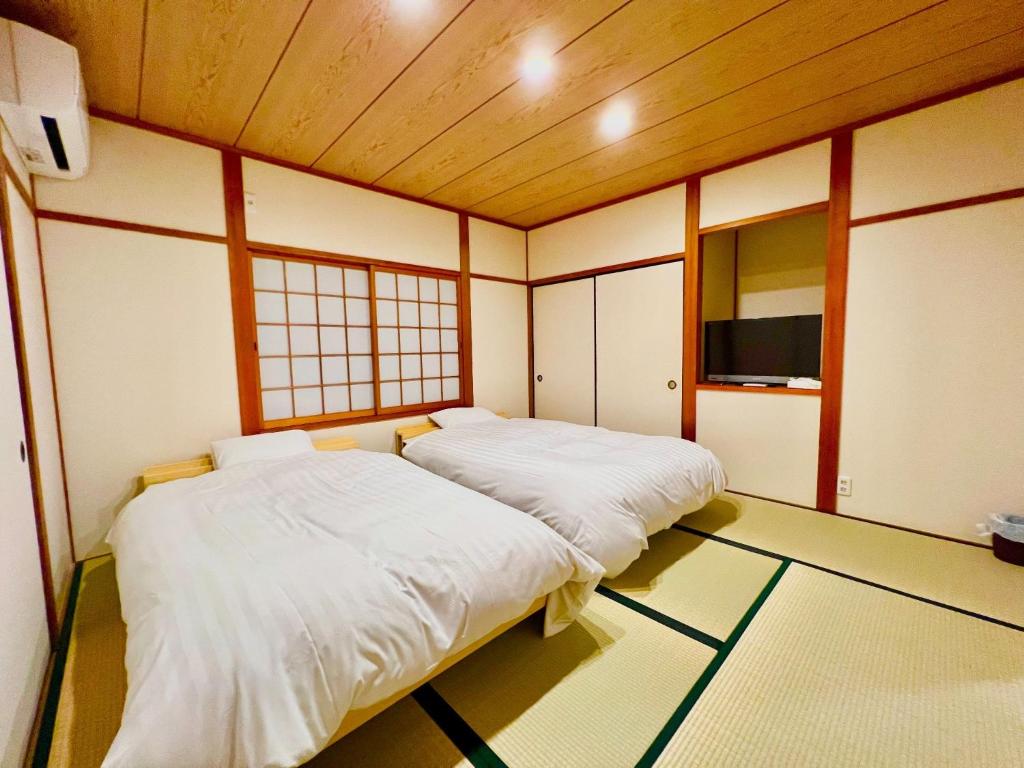 a room with two beds and a tv in it at Geku-mae Bettei Hoshiori - Vacation STAY 65143v in Ise