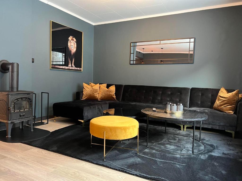 a living room with a black couch and a table at Rjukan Sentrum Apartments NO 1 in Rjukan
