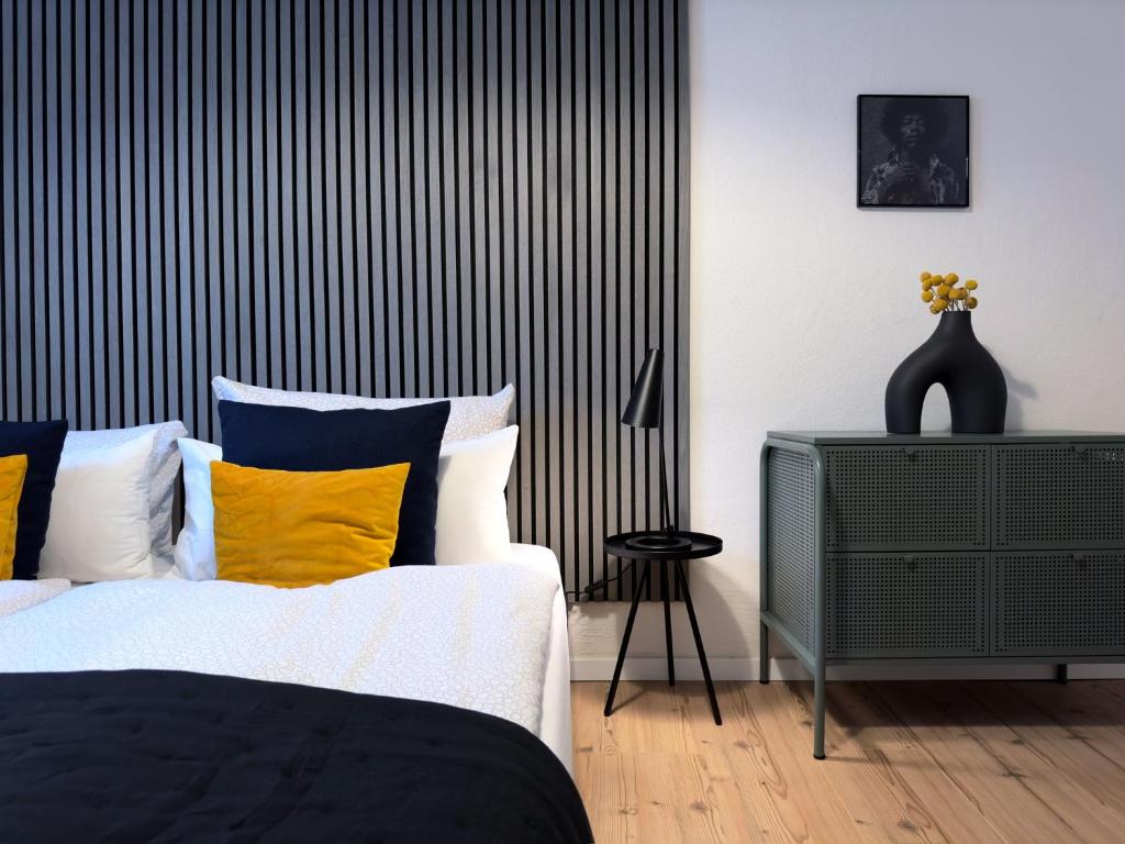 een slaapkamer met een bed met gele en blauwe kussens bij Hip & Minimalist meets Historical Old Town in Pirna