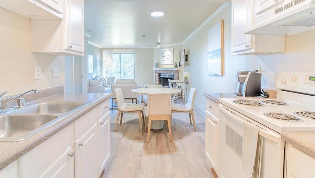 een keuken met een wastafel en een tafel met stoelen bij Landing Modern Apartment with Amazing Amenities (ID8473X04) in Redmond