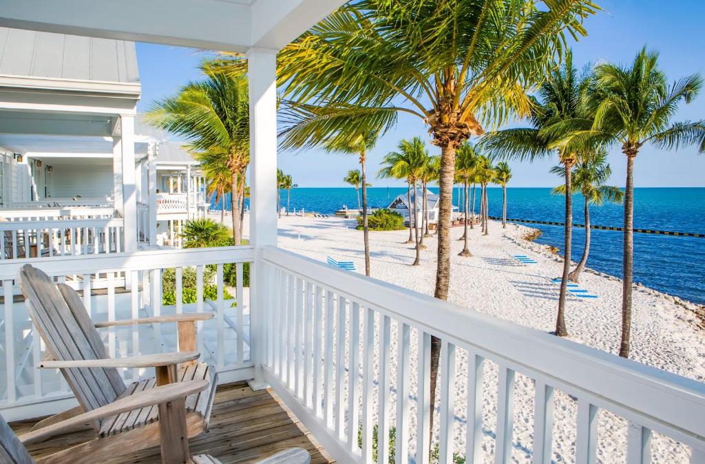 
a beach scene with a balcony overlooking the ocean at Tranquility Bay Resort in Marathon
