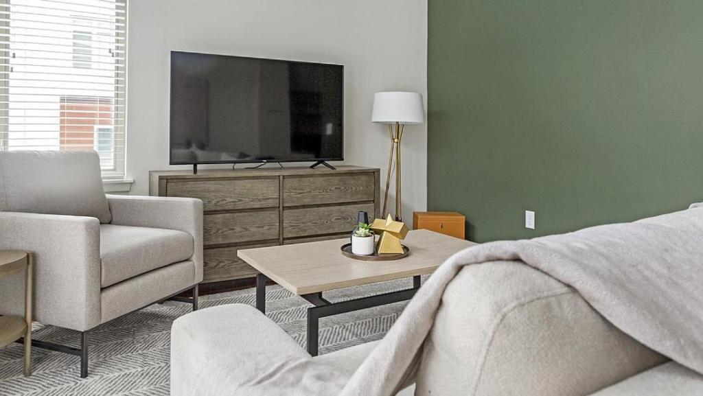 - un salon avec un canapé et une télévision dans l'établissement Landing Modern Apartment with Amazing Amenities (ID6631X57), à Overland Park