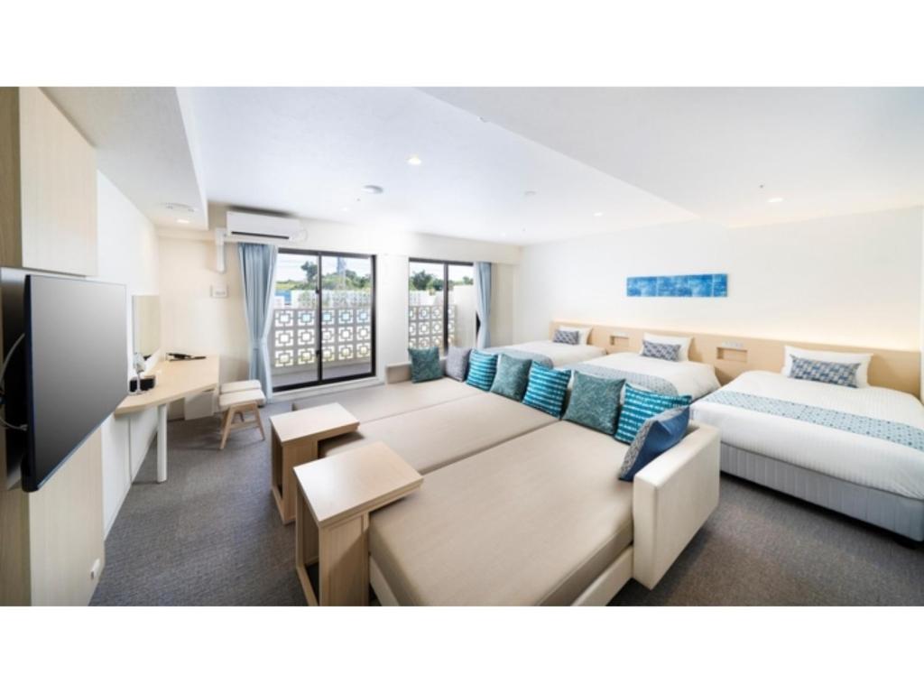 a large room with two beds and a tv at Hotel Torifito Miyakojima Resort - Vacation STAY 79483v in Miyako Island